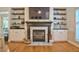 Cozy living room with a fireplace, built-in shelves, and hardwood floors at 340 Andrews Store Rd, Pittsboro, NC 27312
