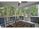 Relaxing screened porch with rocking chairs, ceiling fan, and views of the wooded backyard at 340 Andrews Store Rd, Pittsboro, NC 27312