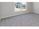 Carpeted bedroom with base trim and a window view of the neighborhood at 534 Glenkirk Pl # 110, Garner, NC 27529