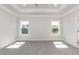 Spacious bedroom with tray ceilings, carpeted floors, and natural light from the windows at 534 Glenkirk Pl # 110, Garner, NC 27529