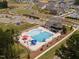 Aerial view of the community pool, playground, parking lot, and surrounding neighborhood at 535 Eversden Dr, Zebulon, NC 27597