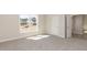 Sunny bedroom with plush carpeting, a large window with neighborhood views, and access to a hallway at 563 Glenkirk Pl # 104, Garner, NC 27529