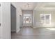 Bright entryway with gorgeous gray wood floors, complemented by a chandelier and natural light from large windows at 563 Glenkirk Pl # 104, Garner, NC 27529