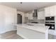 Modern kitchen with white cabinets, a large island, stainless steel appliances, and hardwood flooring at 563 Glenkirk Pl # 104, Garner, NC 27529