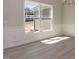 Bright living area featuring a large window with beautiful trim, light-colored hardwood flooring, and an elegant chandelier at 563 Glenkirk Pl # 104, Garner, NC 27529
