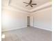 Large main bedroom featuring plush carpet, a modern ceiling fan, and a tray ceiling at 563 Glenkirk Pl # 104, Garner, NC 27529