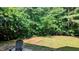 Lush backyard with wooded border, grassy area and patio with outdoor seating at 101 Clardona Way, Holly Springs, NC 27540