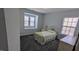 Cozy bedroom featuring a metal bed frame, neutral walls, and ample natural light from two windows at 101 Clardona Way, Holly Springs, NC 27540