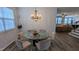 Modern dining area with large glass table, chandelier and hardwood floors at 101 Clardona Way, Holly Springs, NC 27540