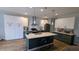 Modern kitchen with gray island, white cabinets, and stainless steel appliances at 101 Clardona Way, Holly Springs, NC 27540