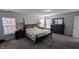Main bedroom with large windows, carpeted flooring and ensuite bathroom entrance at 101 Clardona Way, Holly Springs, NC 27540