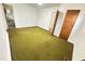 Bedroom featuring green carpet, white walls, and a closet with wooden doors at 204 Hemlock Dr, Durham, NC 27705