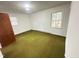 Bedroom featuring green carpet, white walls, and two windows for natural light at 204 Hemlock Dr, Durham, NC 27705