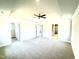 Large main bedroom featuring modern gray carpet, tray ceiling with fan, and doors leading to bathroom and closet at 211 Drayton Hall Ln, Sanford, NC 27330