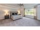 Large main bedroom with tray ceiling, carpet floors, and expansive windows for natural light at 69 Streamline Ct, Lillington, NC 27546