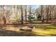 Stone fire pit with a view of the house and woods at 8117 Bud Morris Rd, Wake Forest, NC 27587