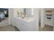 Bathroom with double sink, white cabinets, closet with shelves, and views to the bedroom at 113 Reagan Crest Dr, Clayton, NC 27520