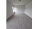 Large, carpeted bedroom with a window offering ample natural light and neutral-colored walls at 120 Vili Dr, Broadway, NC 27505
