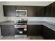 Stylish kitchen featuring dark cabinets, granite countertops, stainless steel appliances, and a modern stove at 120 Vili Dr, Broadway, NC 27505