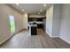 Open kitchen featuring an island, stainless steel appliances, dark cabinetry, and hardwood-style floors at 120 Vili Dr, Broadway, NC 27505