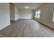 Open-concept living room with wood-look flooring, neutral paint, natural light from a window, and a doorway at 120 Vili Dr, Broadway, NC 27505