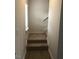 Carpeted stairs with wooden accents leading to the upper level of the home with natural light from a window at 120 Vili Dr, Broadway, NC 27505