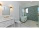 Bright bathroom with double vanity, marble countertop, frameless shower, and a soaking tub at 1425 Sky Vista Way, Raleigh, NC 27613