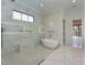 Stylish bathroom showcasing marble tile, herringbone floors, a modern tub, and a glass-enclosed shower at 1425 Sky Vista Way, Raleigh, NC 27613