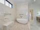 Beautiful bathroom features a modern soaking tub, herringbone tile floor, and luxurious marble walls at 1425 Sky Vista Way, Raleigh, NC 27613