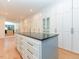 Spacious walk-in closet features custom cabinets, drawers, and a center island with a black countertop at 1425 Sky Vista Way, Raleigh, NC 27613