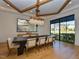 Elegant dining room featuring a modern chandelier, wooden beams, and large windows with neighborhood views at 1425 Sky Vista Way, Raleigh, NC 27613