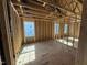Unfinished bedroom featuring wood framing, subfloor and three windows for natural light at 2155 Pink Peony Cir # 235, Durham, NC 27703