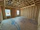 Unfinished bedroom featuring wood framing, subfloor and two windows for natural light at 2155 Pink Peony Cir # 235, Durham, NC 27703