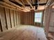 Unfinished bedroom featuring wood framing, subfloor and a window for natural light at 2155 Pink Peony Cir # 235, Durham, NC 27703