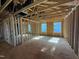 Framed bedroom with visible studs, showcasing natural light from two windows at 2155 Pink Peony Cir # 235, Durham, NC 27703