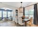Dining room with natural light, a modern chandelier, and stylish decor, adjoining the living room with elegant accents at 2155 Pink Peony Cir # 235, Durham, NC 27703