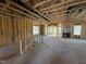 Framed living room showing open windows and wall studs, creating a bright and airy space with a fireplace at 2155 Pink Peony Cir # 235, Durham, NC 27703