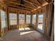 Bright sun room with visible studs, showcasing natural light and the door to the exterior of the home at 2155 Pink Peony Cir # 235, Durham, NC 27703