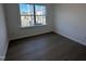 Bedroom featuring wood flooring, a neutral color scheme, and a large window for natural light at 5168 Church Rd # 22, New Hill, NC 27562