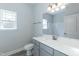 Bathroom features a gray vanity, white countertop, single sink, large mirror, and neutral paint at 587 Glenkirk Pl, Garner, NC 27529