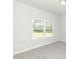 A bedroom features neutral walls, carpet flooring, and two bright windows bringing in natural light at 587 Glenkirk Pl, Garner, NC 27529