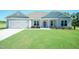 Charming single-story home with a well-manicured lawn, a two-car garage and stone accents at 587 Glenkirk Pl, Garner, NC 27529