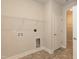 Laundry room with storage shelves, tile flooring, utility sink, and connections for washer and dryer at 587 Glenkirk Pl, Garner, NC 27529