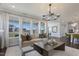 A well-lit living room features large windows, plush seating, and modern decor at 909 Jasper Mine Trl, Raleigh, NC 27610