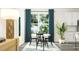 Sunlit dining area with a modern table, seating for four, elegant décor, and a large window with lovely drapery at 913 Jasper Mine Trl, Raleigh, NC 27610