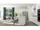 White eat-in kitchen featuring quartz counters, stainless appliances, shaker cabinets, counter seating, and natural lighting at 913 Jasper Mine Trl, Raleigh, NC 27610