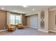 A cozy basement with ample natural light and two comfortable chairs and unique wall art at 921 Jasper Mine Trl, Raleigh, NC 27610
