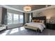 The main bedroom features large windows, tray ceiling, and a stunning chandelier at 921 Jasper Mine Trl, Raleigh, NC 27610