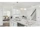 Modern kitchen featuring an island, stainless steel appliances, and seamless flow to the dining and living areas at 1319 Hollyview Ave, Durham, NC 27703