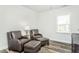 Sitting area with hardwood floors featuring two leather chairs and ottomans and a window at 1319 Hollyview Ave, Durham, NC 27703